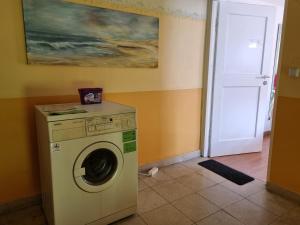 een wasmachine in een kamer met een schilderij aan de muur bij Haus Kreuzeckwiese - Self Catering Apartments in Garmisch-Partenkirchen