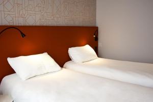 two beds sitting next to each other in a room at ibis Rodez Centre in Rodez