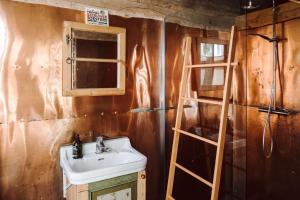 ein Badezimmer mit einem Waschbecken und einer Holzwand in der Unterkunft Projektraum Obst und Sterne 