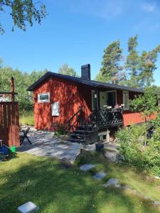 a red cabin with a porch and stairs to it at Stugan in Stockholm