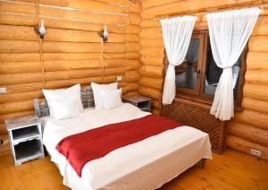 um quarto com uma cama num chalé de madeira em Domeniul Haiducilor Bucovina em Suceava
