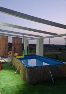 een zwembad met een luifel en een speeltuin bij Villa Vincenza in Melilli