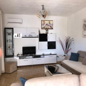 un soggiorno con divano e TV di Arsen Apartments a Sarandë
