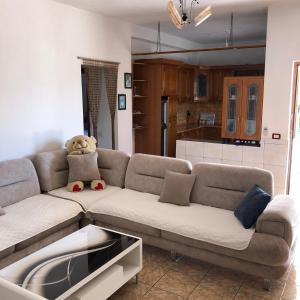 un soggiorno con divano e orsacchiotto di Arsen Apartments a Sarandë