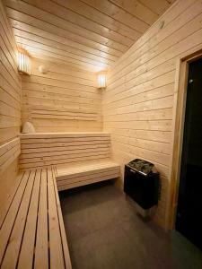 a sauna with a bench in a wooden wall at Zagaje Pokoje Gościnne in Sarbinowo