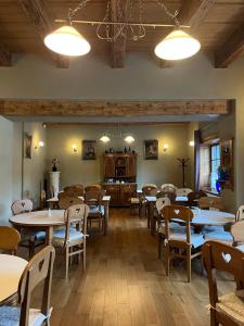 una sala da pranzo con tavoli, sedie e luci di Pensiunea Tohanu Vechi a Zărneşti