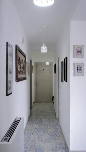 a hallway with white walls and a hallway with art on the walls at Affittacamere DOMO AGORA' in Tertenìa +13 photos