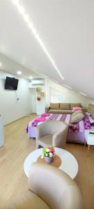 a large room with two beds and a table at Maslina Rooms in Smederevo