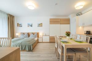 - une chambre et une salle à manger avec un lit et une table dans l'établissement MF Port Azúr Wellness Apartments, à Siófok