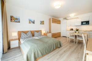 Cet appartement comprend une chambre avec un lit et une table ainsi qu'une cuisine. dans l'établissement MF Port Azúr Wellness Apartments, à Siófok