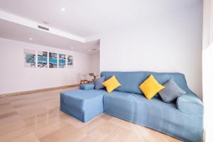 a blue couch in a living room with yellow pillows at Aparthotel Napols - Abapart in Barcelona
