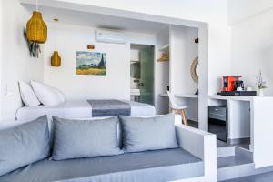 a white room with a couch and a bed at Skopelos Holidays Hotel & Spa in Skopelos Town