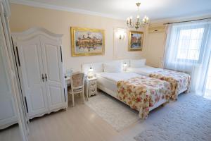 a bedroom with two beds and a desk and a chandelier at Villa Alice in Suceava