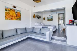 a living room with a couch and a bed at Skopelos Holidays Hotel & Spa in Skopelos Town