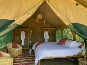 sypialnia z łóżkiem w namiocie w obiekcie Echoes of Eden: River Retreat w mieście Naivasha