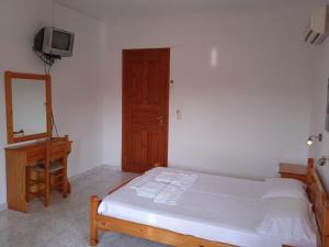 a bedroom with a bed and a dresser and a mirror at Platanakia in Skopelos Town +25 photos