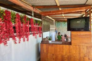 a bar with red flowers hanging from a wall at SPOT ON 92699 Irish Irish Homestay in Banyuwangi