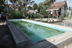 a pool of water in front of a house at SPOT ON 92699 Irish Irish Homestay in Banyuwangi