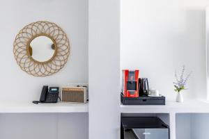 a white shelf with a mirror and a telephone at Skopelos Holidays Hotel & Spa in Skopelos Town