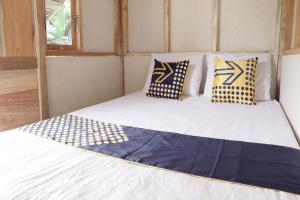 łóżko z biało-niebieskimi poduszkami w pokoju w obiekcie SPOT ON 92699 Irish Irish Homestay w mieście Banyuwangi
