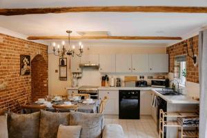 cocina y comedor con mesa y sillas en The Threshing Barn - relaxing countryside spa break, en Pentney