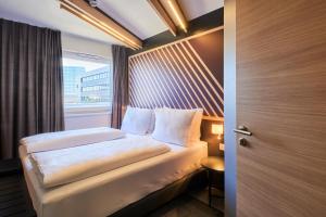 a small bedroom with a bed and a window at B&B HOTEL Frankfurt-Niederrad in Frankfurt/Main