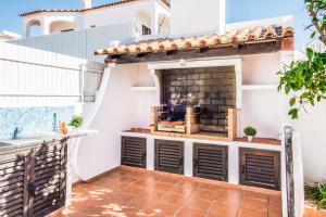 a patio with a fireplace on the side of a house at Villa Mar Gale in Galé