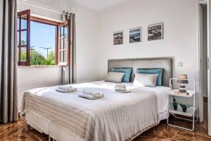 a white bedroom with a large bed and a window at Villa Mar Gale in Galé
