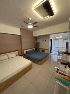 a bedroom with two beds and a ceiling fan at Ulike Homestay-3Room-4 king Size Bed-The Venus in Sitiawan