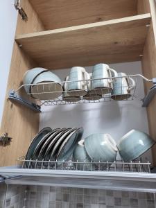 a shelf with plates and pans in a refrigerator at Mara Apartment in Năvodari