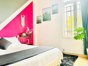 - une chambre avec un mur d'accent rose et un lit dans l'établissement TAM GIAC MẠCH HOUSE, à Đà Lạt