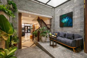 a living room with a couch and some plants at Hanoi La Palm Premier Hotel & Spa in Hanoi