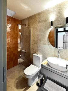 a bathroom with a toilet and a sink and a mirror at Koy Villa in Muğla