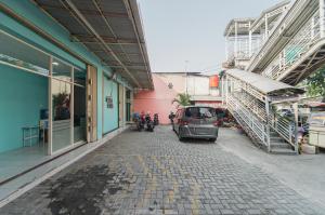 um carro estacionado numa rua ao lado de um edifício em RedDoorz Syariah at MN One Cempaka Putih em Jakarta