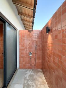 Koy Villa في موغلا: حمام مع دش مع بلاط برتقالي على الحائط