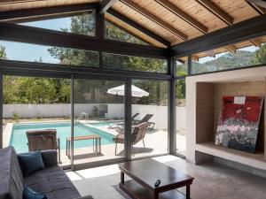 a living room with a fireplace and a swimming pool at Koy Villa in Muğla