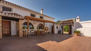 eine Terrasse eines Hauses mit einem Tisch und Stühlen in der Unterkunft Cortijo Alzamigaja Archidona by Ruralidays in Archidona