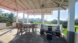 a patio with a table and chairs and a view at Villa Crimson Bay in Unawatuna