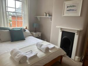 a bedroom with a bed with towels on it at Seagulls Cottage in the heart of Exmouth in Exmouth