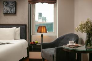 a bedroom with a bed and a chair and a table at Hanoi La Palm Premier Hotel & Spa in Hanoi +64 photos