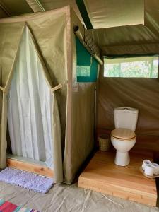 a bathroom with a toilet in a tent at Echoes of Eden: Forest Haven in Melewa