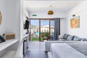 a hotel room with a bed and a living room at Skopelos Holidays Hotel & Spa in Skopelos Town