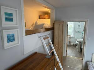 a room with a bunk bed with a ladder and a desk at Seagulls Cottage in the heart of Exmouth in Exmouth