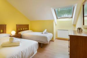 a bedroom with two beds and a window at Atico la Espata Villanua in Villanúa