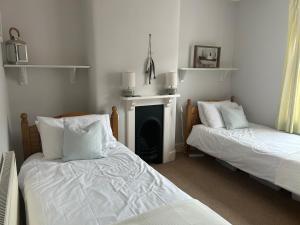 a room with two beds and a fireplace in it at Seagulls Cottage in the heart of Exmouth in Exmouth