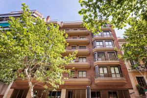 an apartment building with trees in front of it at Aparthotel Napols - Abapart in Barcelona