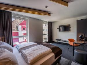 ein Hotelzimmer mit einem Bett und einem großen Fenster in der Unterkunft B&B Hotel Villingen-Schwenningen in Villingen-Schwenningen