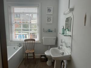 a bathroom with a sink and a toilet and a bath tub at Seagulls Cottage in the heart of Exmouth in Exmouth