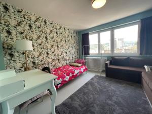 ein kleines Wohnzimmer mit einem Sofa und einem Bett in der Unterkunft Amazing penthouse in Sarajevo