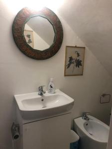 a bathroom with a sink and a mirror on the wall at Suali Case nel Borgo in Civita Castellana +41 photos